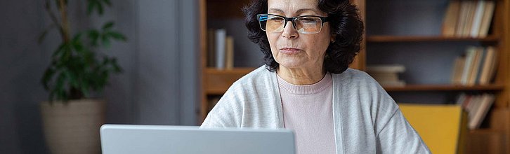 Frau sitzt am Laptop