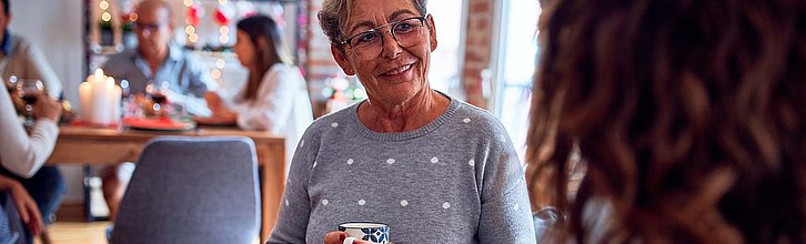 Frau mit Kaffeetasse in der Hand im Gespräch